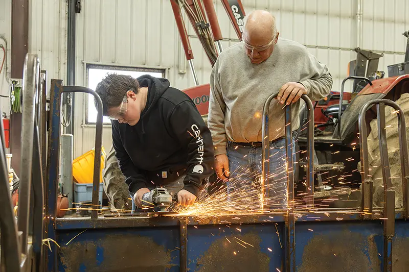 two people in a metal workshop